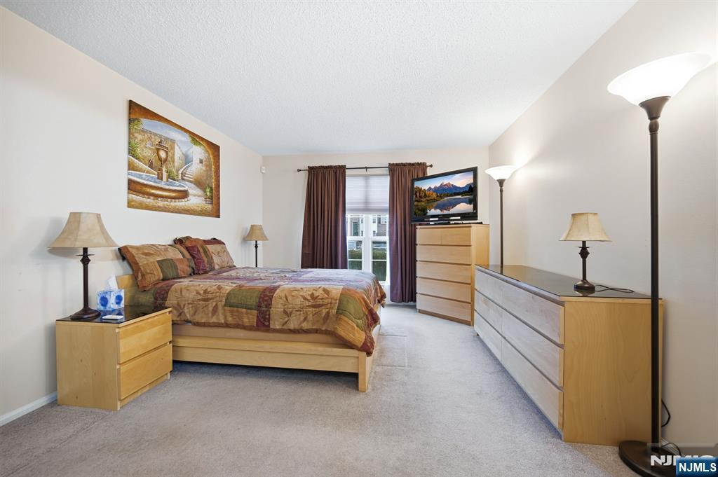 475 Quince Court Mahwah, NJ 07430 - Photo 15 of 27 a spacious bedroom with a bed and a lamp