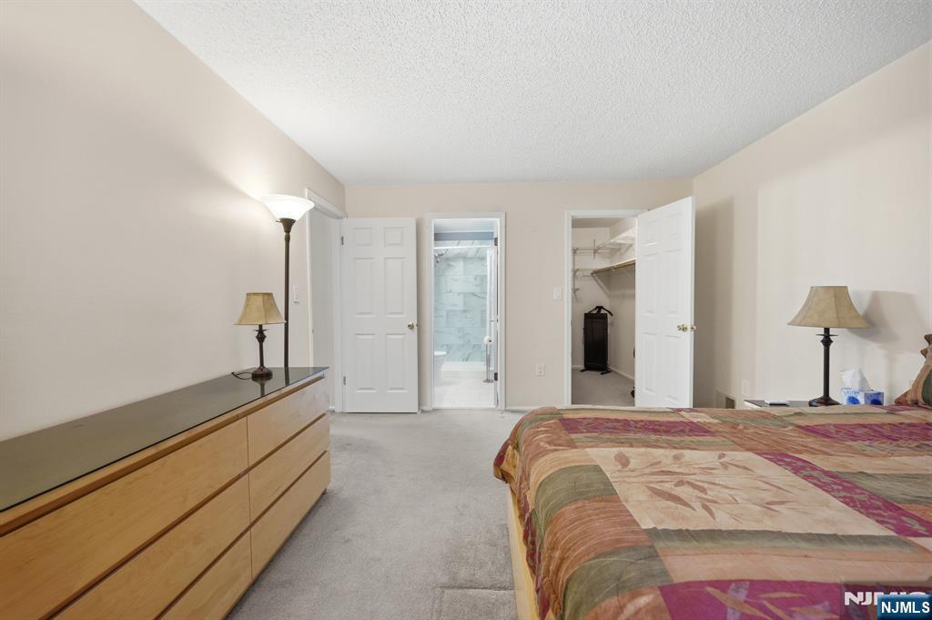 475 Quince Court Mahwah, NJ 07430 - Photo 17 of 27 a spacious bedroom with a bed and a large mirror