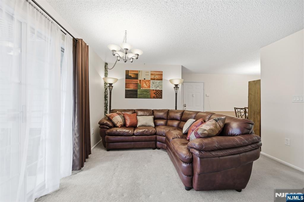 475 Quince Court Mahwah, NJ 07430 - Photo 9 of 27 a living room with furniture and a chandelier
