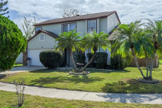 a view of a house with backyard and trees