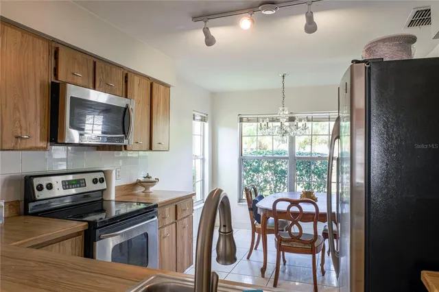 a kitchen with stainless steel appliances granite countertop a stove top oven a sink and a refrigerator