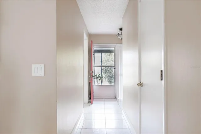 a view of a hallway with wooden floor and a bathroom