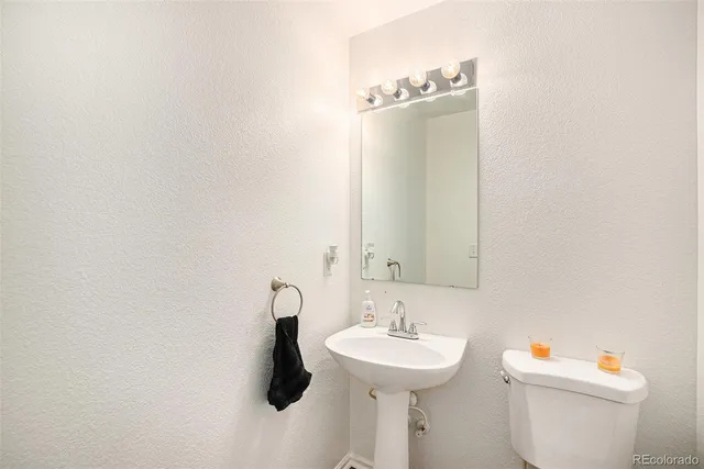 a bathroom with a sink a toilet and mirror