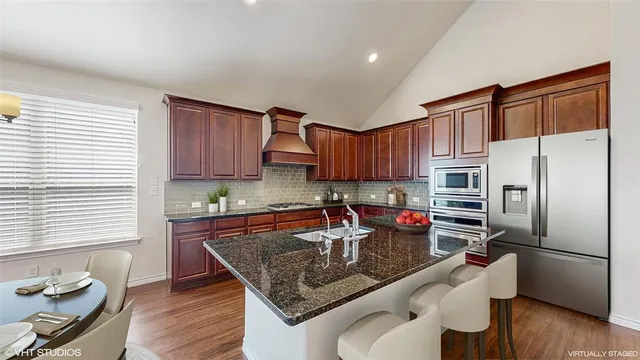 a kitchen with stainless steel appliances granite countertop a sink stove and cabinets