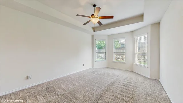 an empty room with closet and a ceiling fan