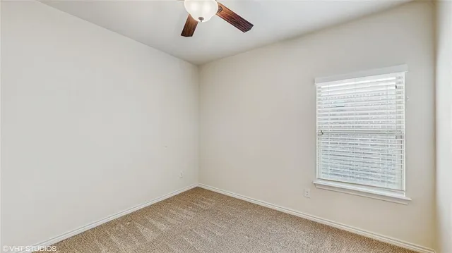 an empty room with closet and a ceiling fan