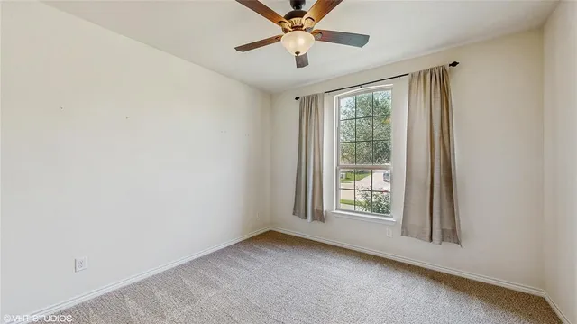 a view of empty room with wooden floor and windows
