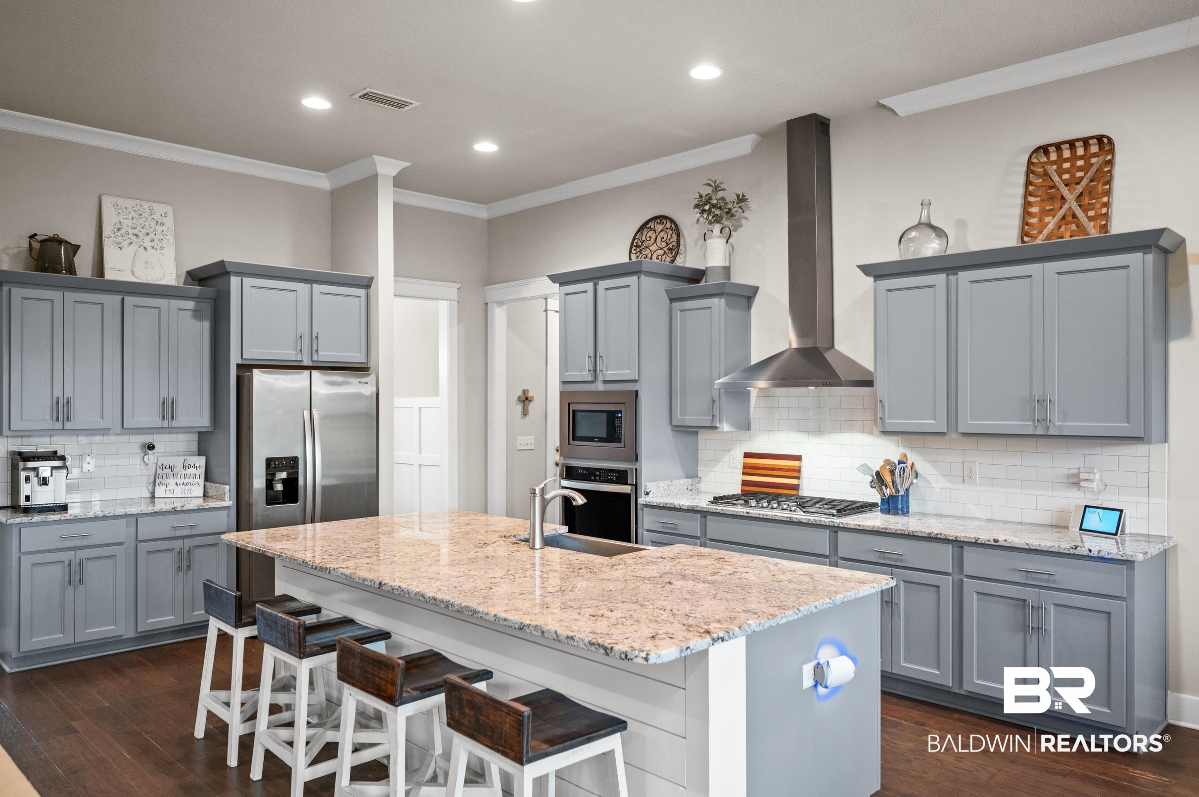 31355 Limpkin Street Daphne, AL 36527 - Photo 17 of 57 Kitchen with appliances with stainless steel finishes, dark hardwood / wood-style flooring, a kitchen breakfast bar, wall chimney range hood, and an island with sink