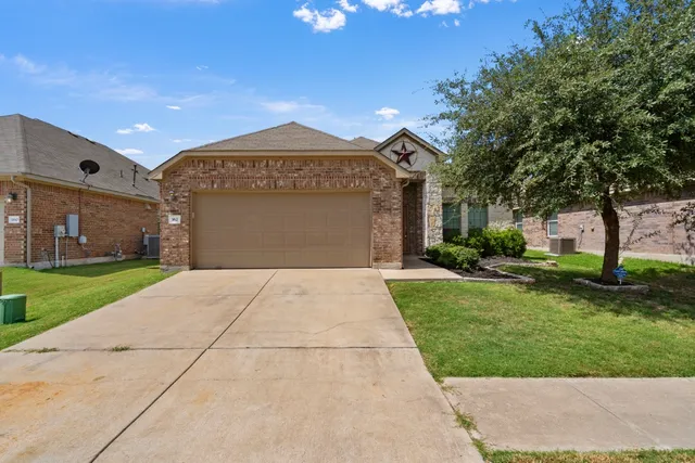 a view of a house with backyard and tree