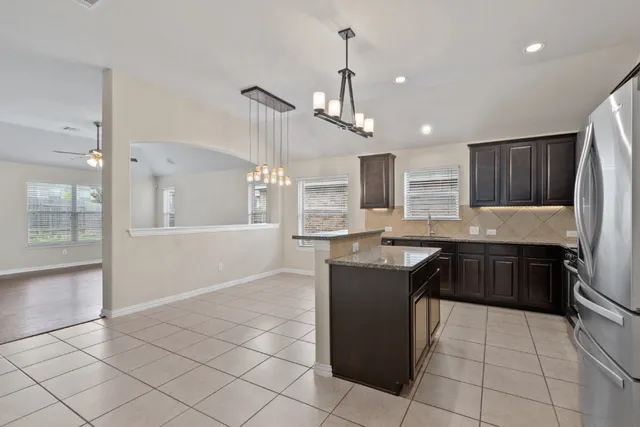 a kitchen with granite countertop cabinets sink and window