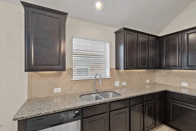a kitchen with granite countertop stainless steel appliances and wooden cabinets