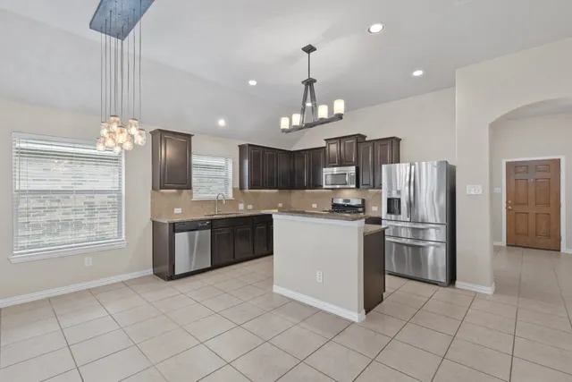 a kitchen with a sink a stove and cabinets