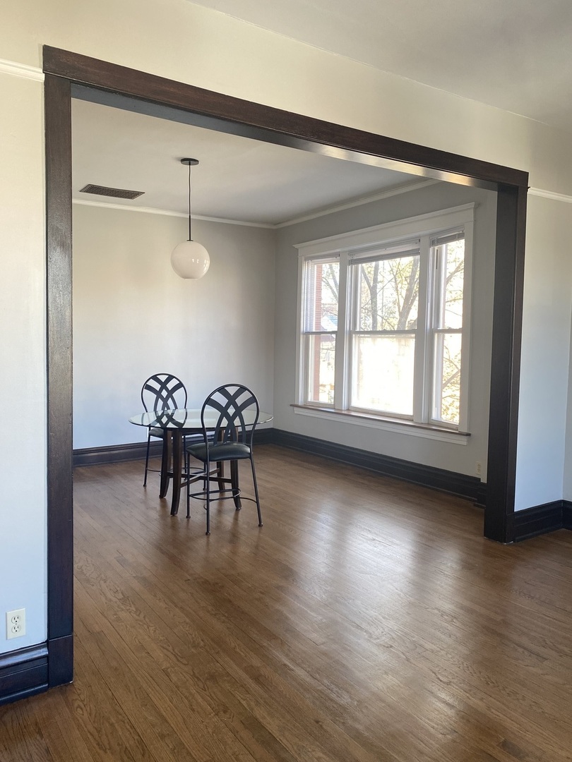 2898 North Milwaukee Avenue, Unit 2 Chicago, IL 60618 - Photo 2 of 10 an empty room with wooden floor and a large window
