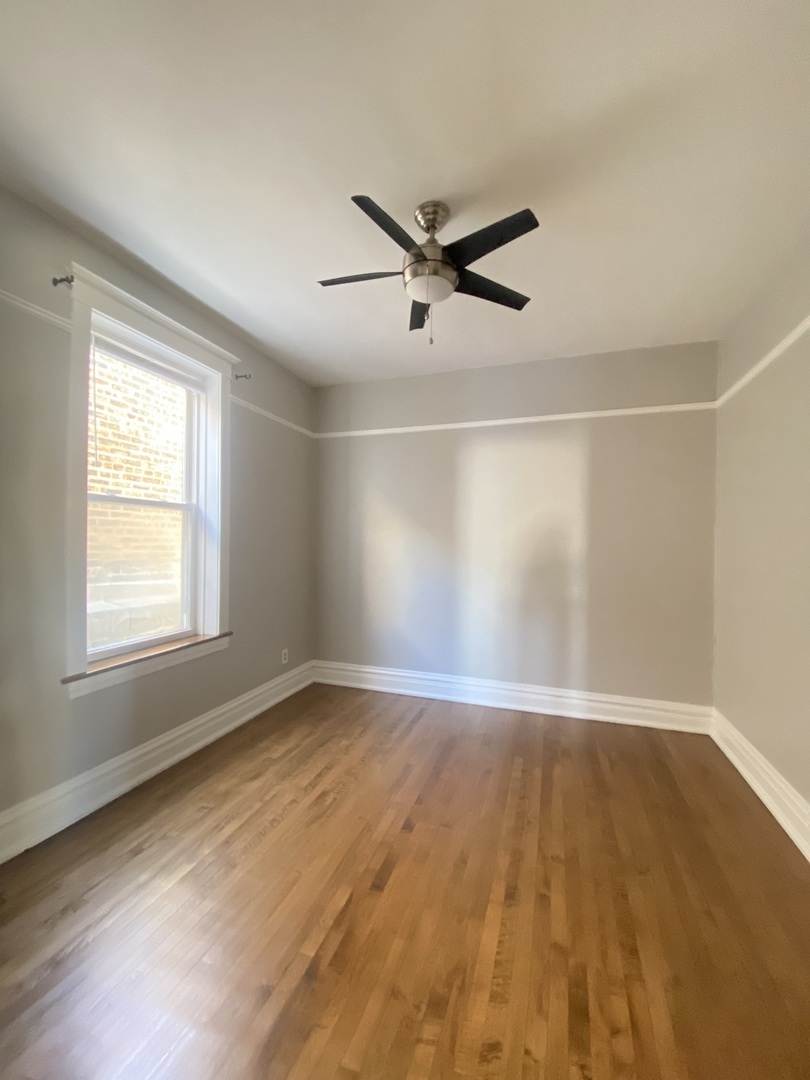 2898 North Milwaukee Avenue, Unit 2 Chicago, IL 60618 - Photo 6 of 10 an empty room with wooden floor and windows