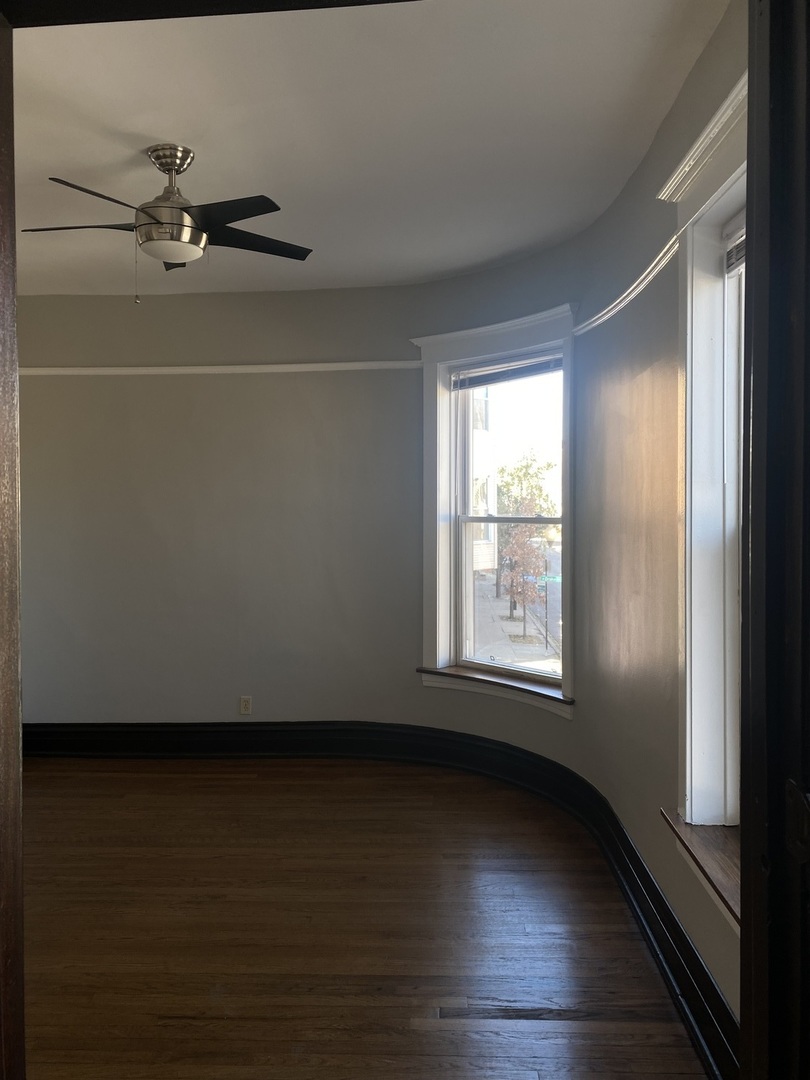 2898 North Milwaukee Avenue, Unit 2 Chicago, IL 60618 - Photo 7 of 10 an empty room with wooden floor and windows