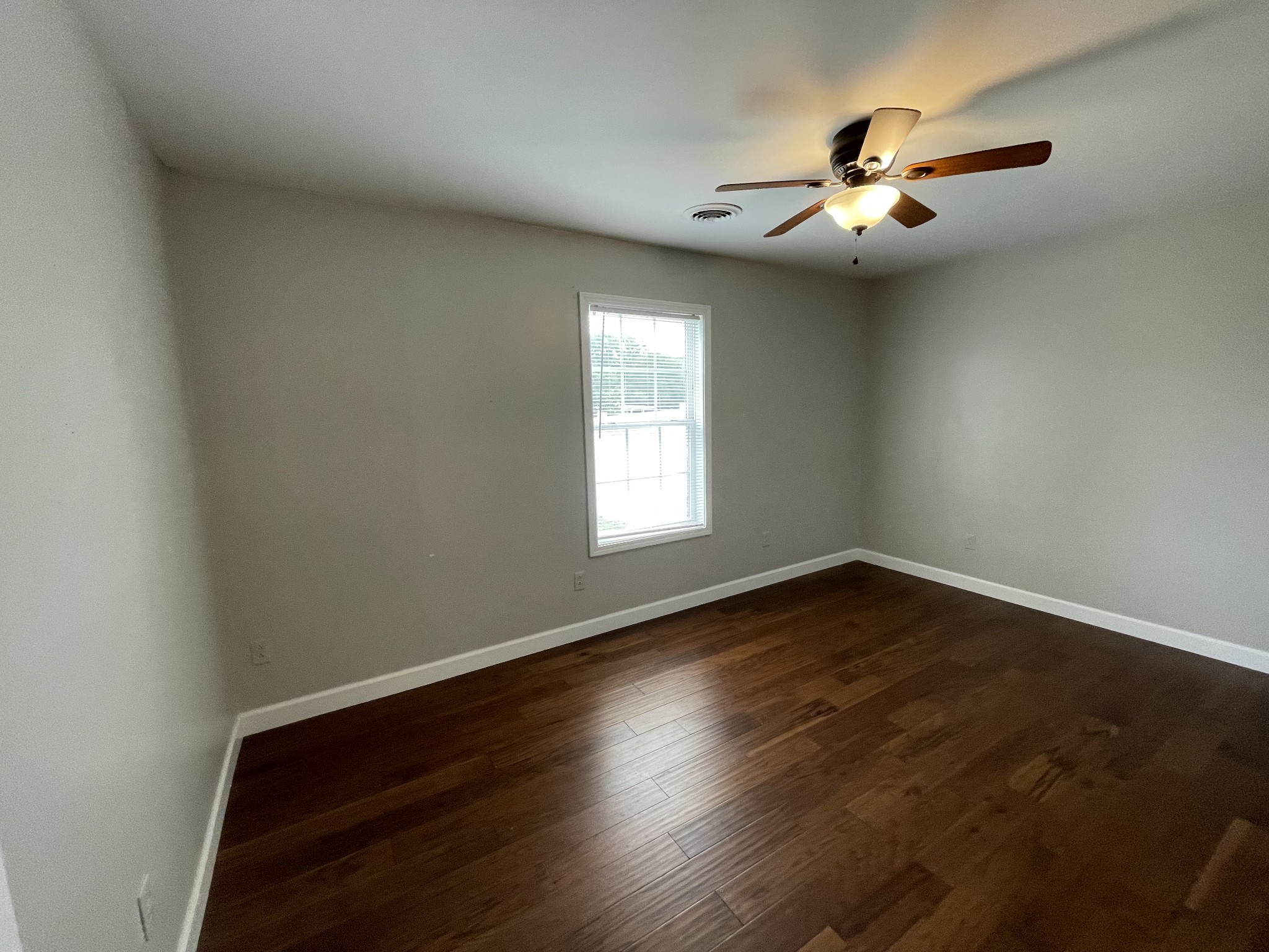 305 Cedar Hill Road Adams, TN 37010 - Photo 28 of 34 an empty room with wooden floor chandelier fan and windows