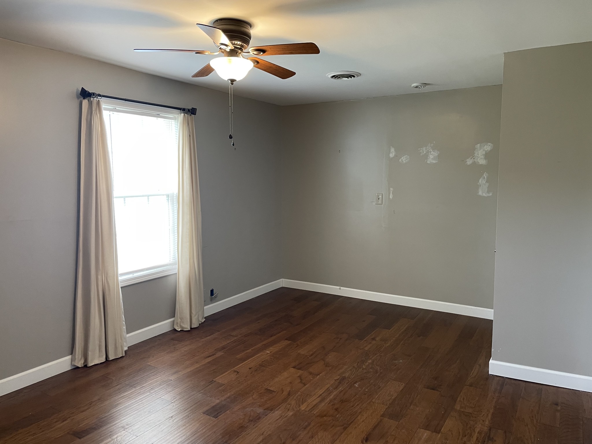 305 Cedar Hill Road Adams, TN 37010 - Photo 29 of 34 an empty room with wooden floor chandelier fan and windows