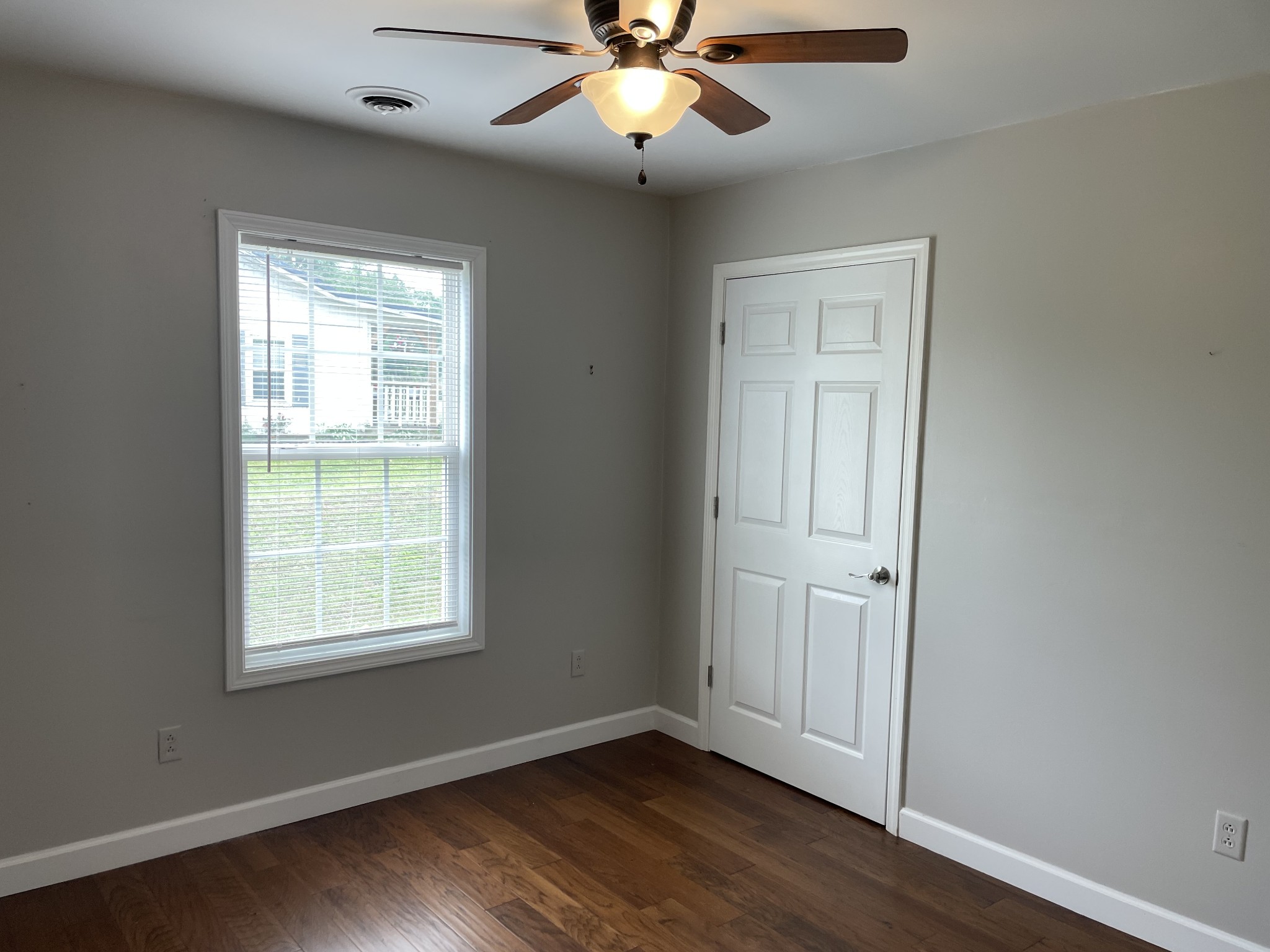 305 Cedar Hill Road Adams, TN 37010 - Photo 31 of 34 an empty room with wooden floor chandelier fan and windows