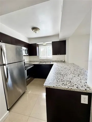 a kitchen with stainless steel appliances granite countertop a sink and a refrigerator