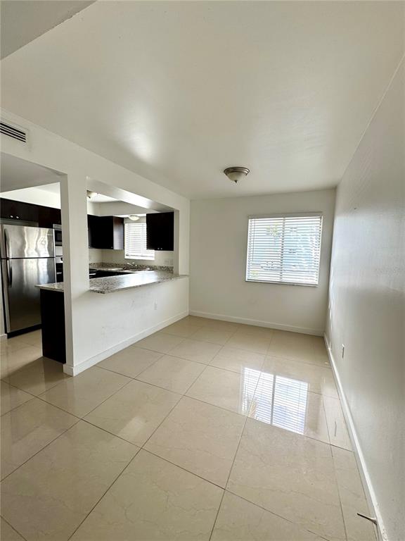 13300 Walsingham Road, Unit 61 Largo, FL 33774 - Photo 3 of 18 a view of a electric appliances in kitchen and empty room with wooden floor