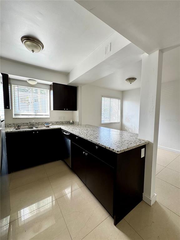 13300 Walsingham Road, Unit 61 Largo, FL 33774 - Photo 6 of 18 a kitchen with granite countertop a sink and a wooden floor