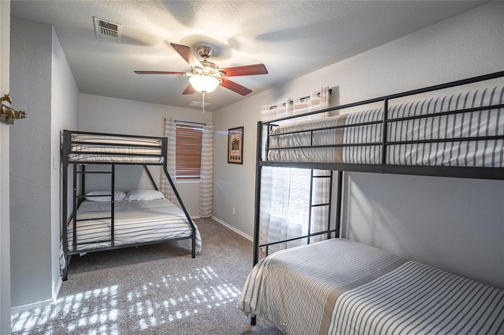 2702 River Ridge Court Granbury, TX 76048 - Photo 14 of 21 Bedroom featuring carpet floors, ceiling fan, a textured ceiling, and a textured wall