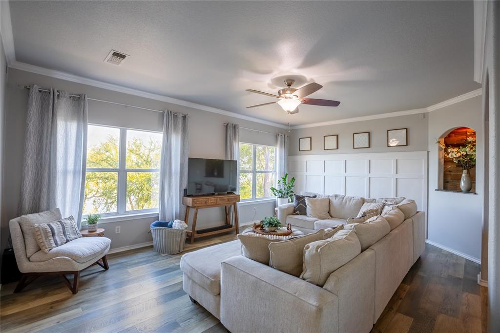 2702 River Ridge Court Granbury, TX 76048 - Photo 5 of 21 Living room with crown molding, ceiling fan, and dark wood-type flooring