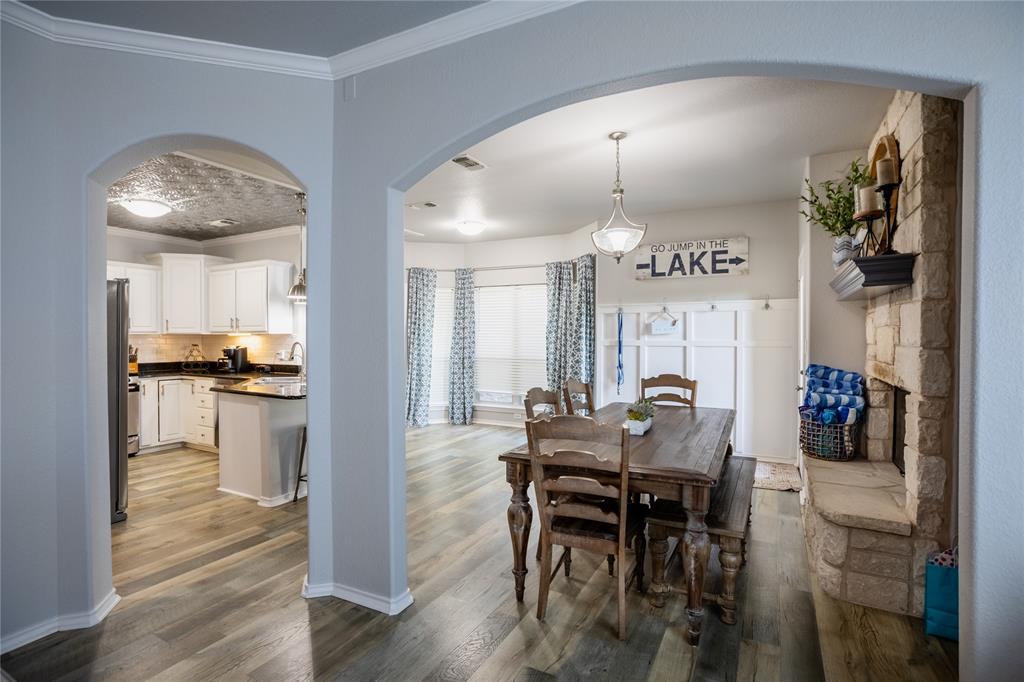 2702 River Ridge Court Granbury, TX 76048 - Photo 6 of 21 Dining room featuring arched walkways, ornamental molding, and dark wood-style floors