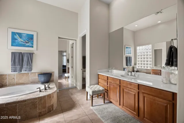 a bathroom with a granite countertop tub sink and mirror