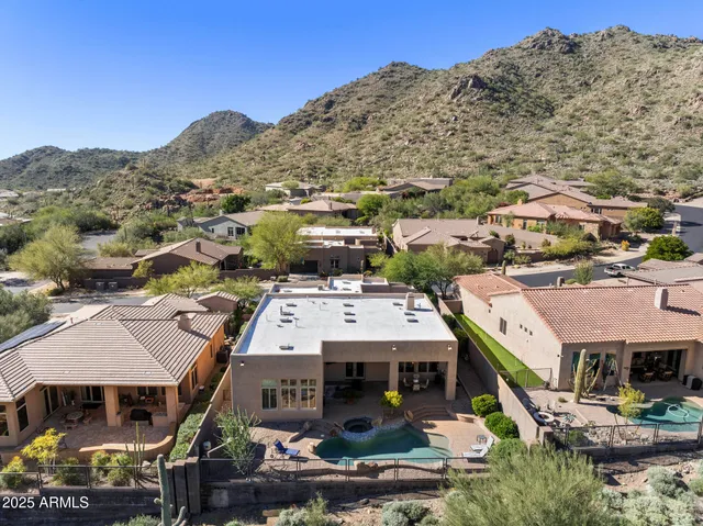 an aerial view of a house with a mountain