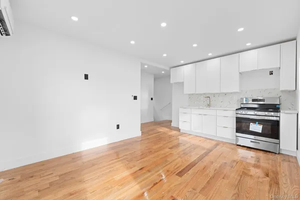 a large white kitchen with stainless steel appliances granite countertop a stove a sink and a microwave