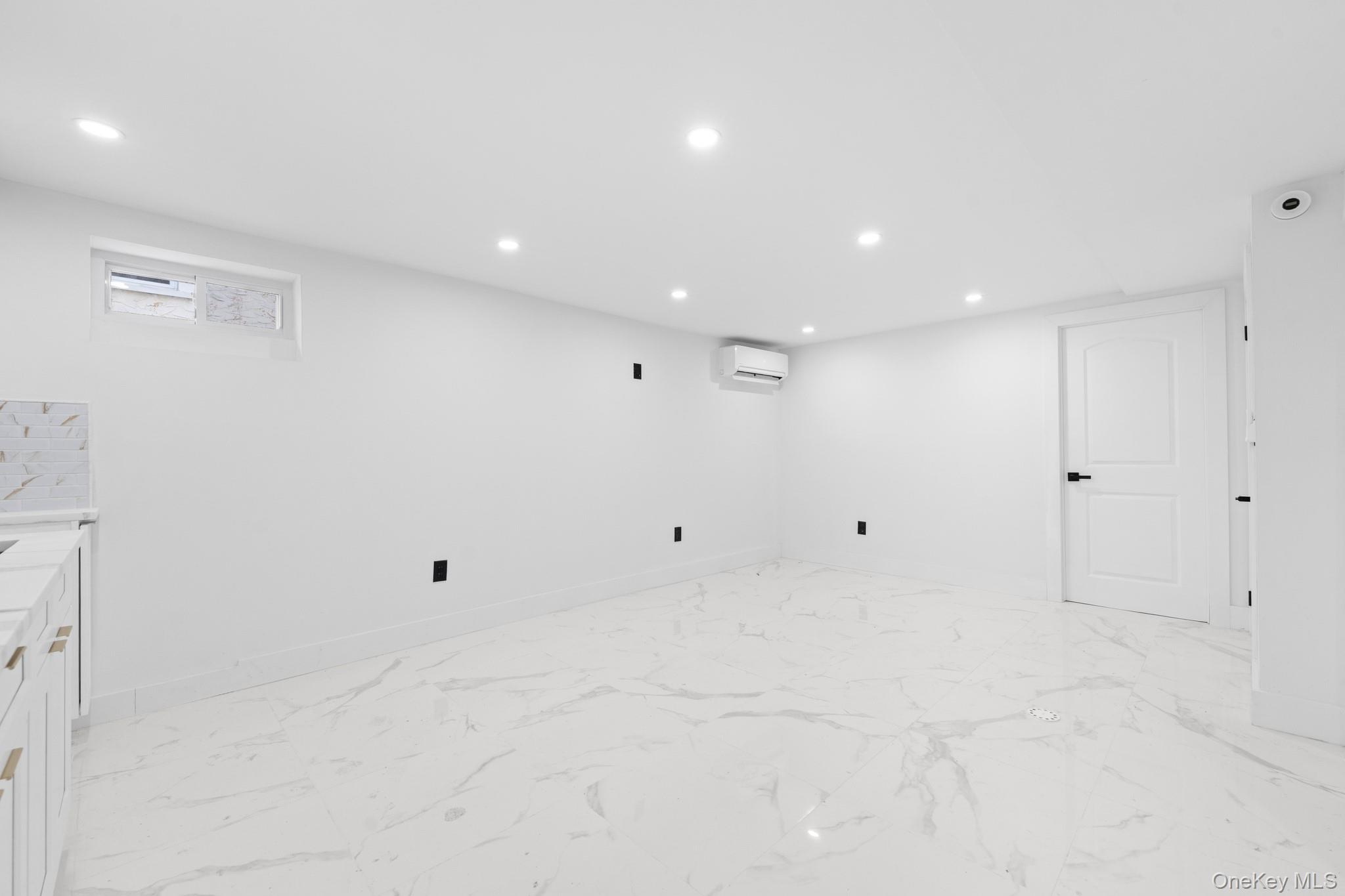 115-39 202nd Street Queens, NY 11412 - Photo 18 of 29 Below grade area featuring recessed lighting, light marble finish flooring, and an AC wall unit
