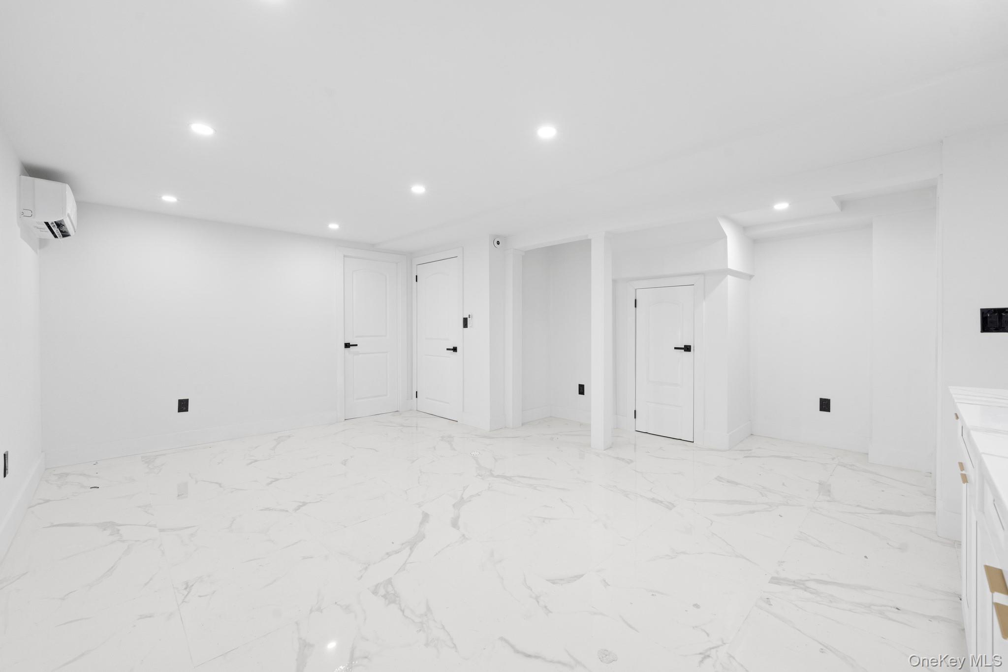 115-39 202nd Street Queens, NY 11412 - Photo 19 of 29 Basement featuring recessed lighting, light marble finish flooring, and a wall mounted air conditioner