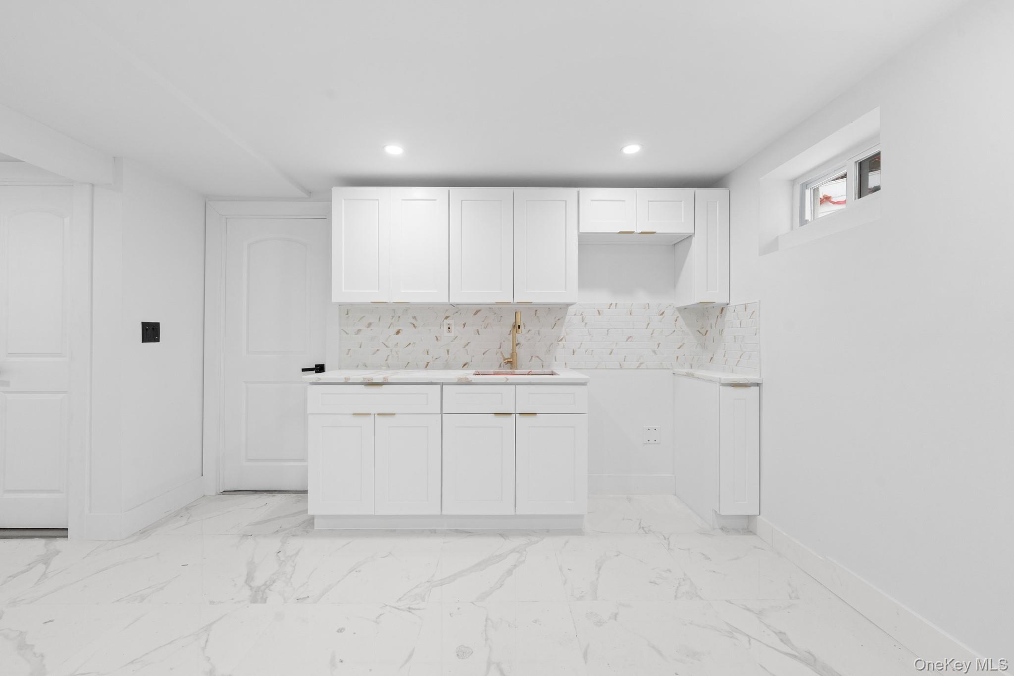 115-39 202nd Street Queens, NY 11412 - Photo 20 of 29 Kitchen featuring white cabinets, backsplash, light countertops, recessed lighting, and light marble finish flooring