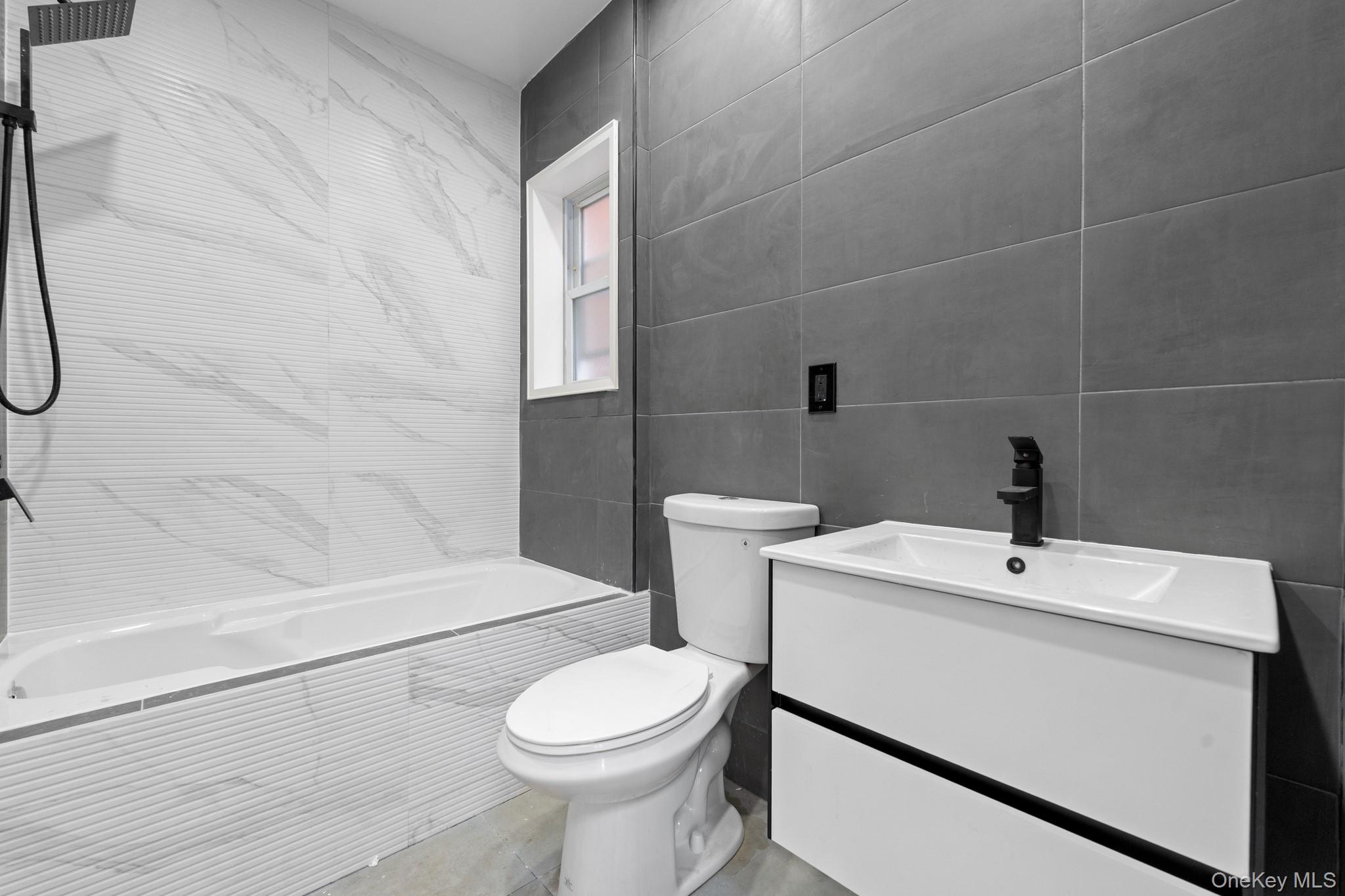 115-39 202nd Street Queens, NY 11412 - Photo 23 of 29 Bathroom featuring vanity, tile walls, and tiled shower / bath