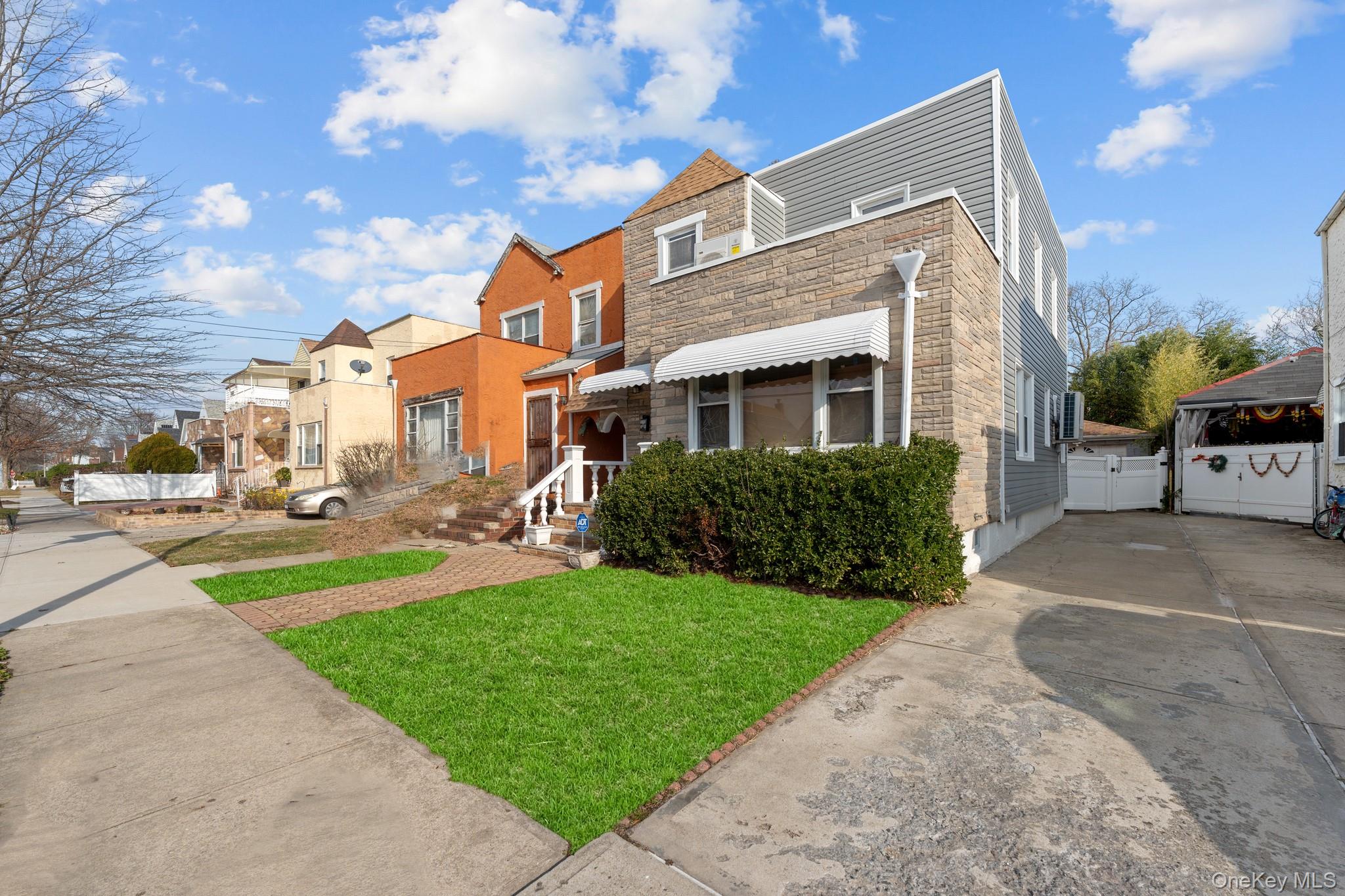 115-39 202nd Street Queens, NY 11412 - Photo 26 of 29 View of front facade featuring a front lawn, stone siding, and a residential view