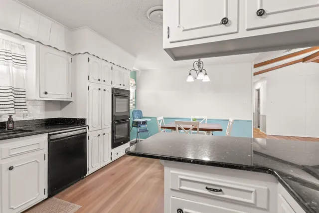 a kitchen with a refrigerator and white cabinets