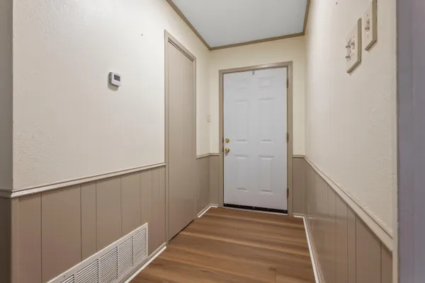 a view of a hallway with wooden floor and staircase