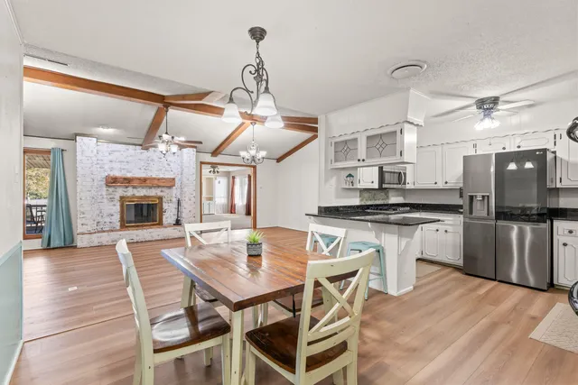 a kitchen with a dining table chairs and refrigerator