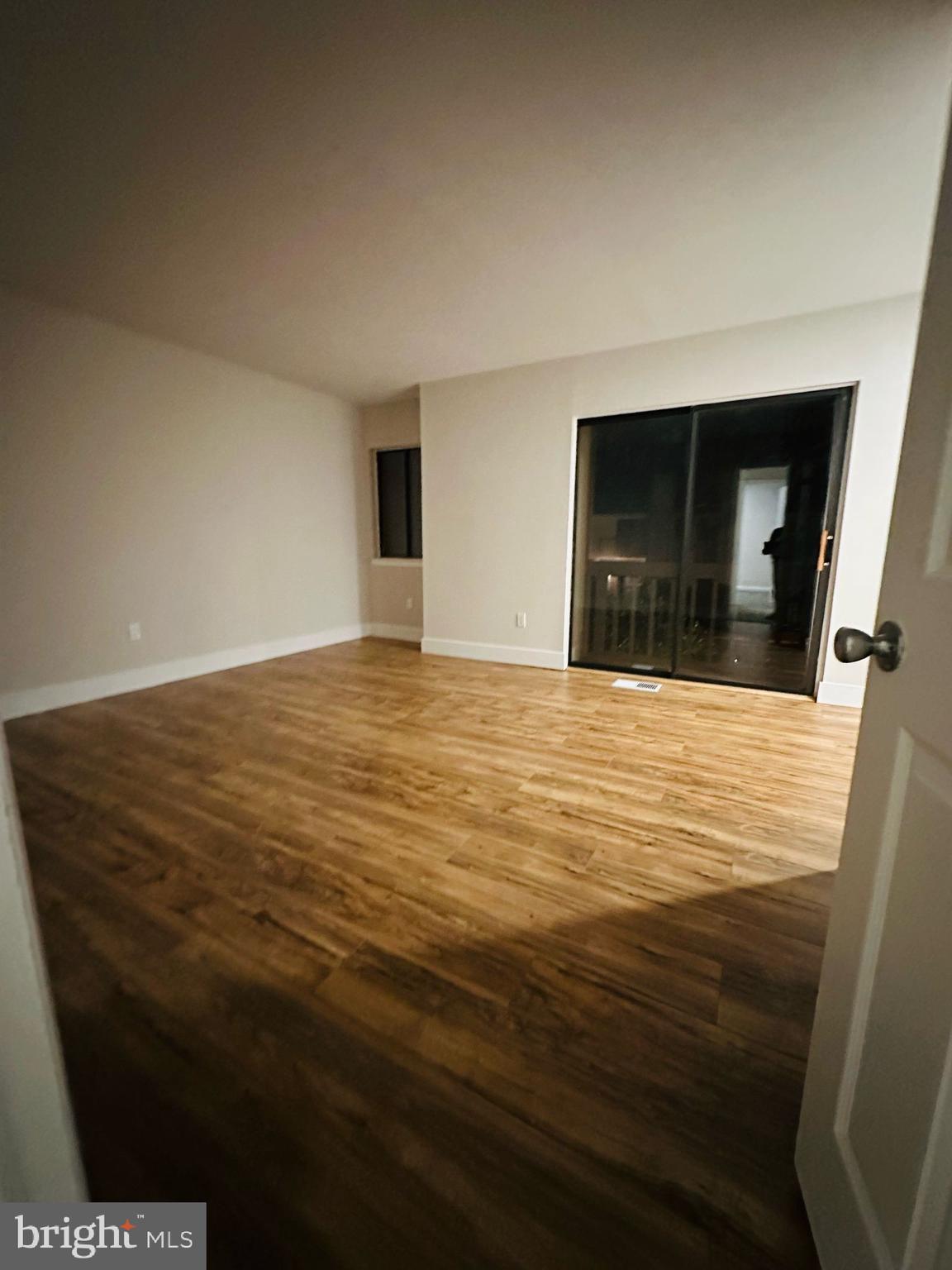 33 Trowbridge Lane Clementon, NJ 08021 - Photo 9 of 20 a view of an empty room with wooden floor and kitchen