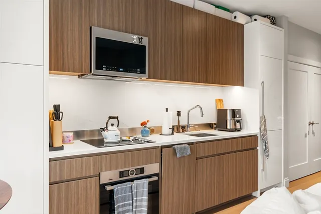 a kitchen with stainless steel appliances a sink a stove and a microwave