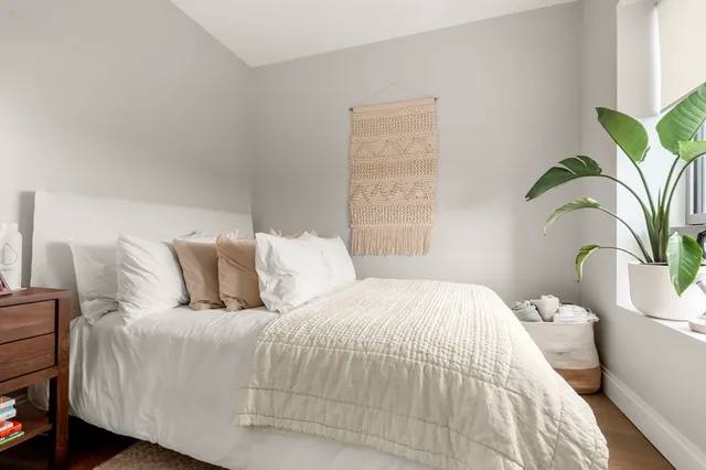 a large bed sitting in a bedroom next to a window