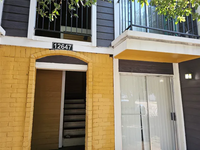 a view of a house with a door and wooden walls