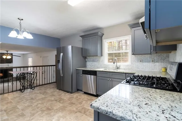 a kitchen with stainless steel appliances granite countertop a sink stove and refrigerator