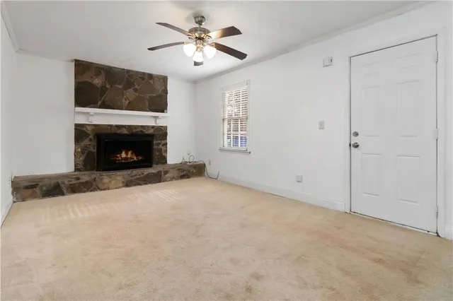 a view of empty room with fireplace and fan