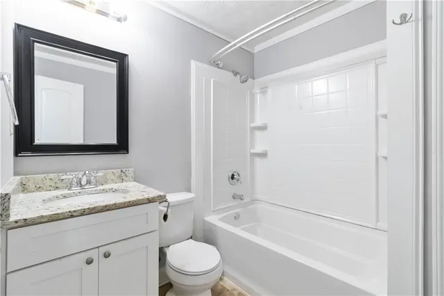 a bathroom with a toilet a sink a mirror a bathtub and vanity