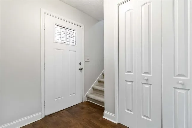 a view of a hallway with wooden floor and entryway