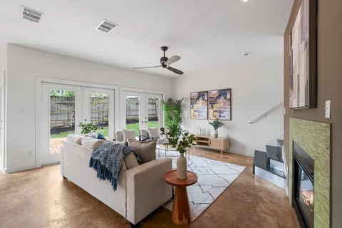 a living room with furniture a fireplace and a large window