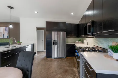 a kitchen with kitchen island stainless steel appliances a sink stove and refrigerator
