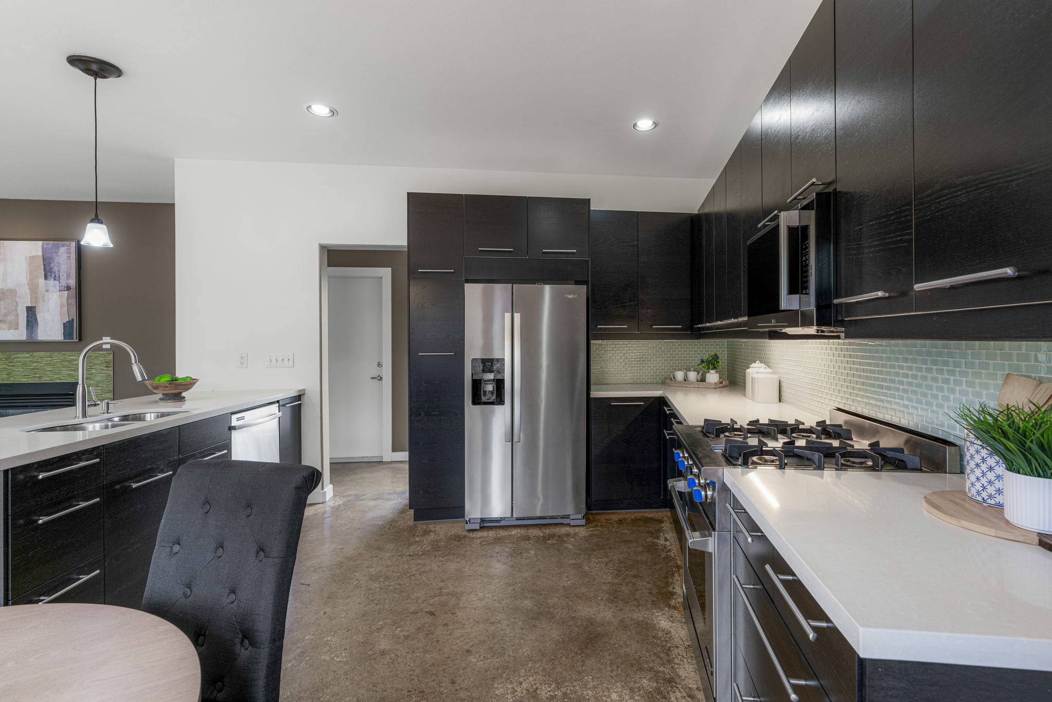 2114 Goodrich Avenue, Unit 10 Austin, TX 78704 - Photo 13 of 35 The updated kitchen features stainless steel appliances, sleek countertops, stylish tile backsplash, and a layout designed for functionality and style.